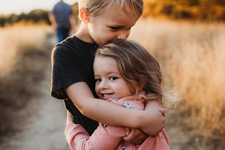 two children hugging outside